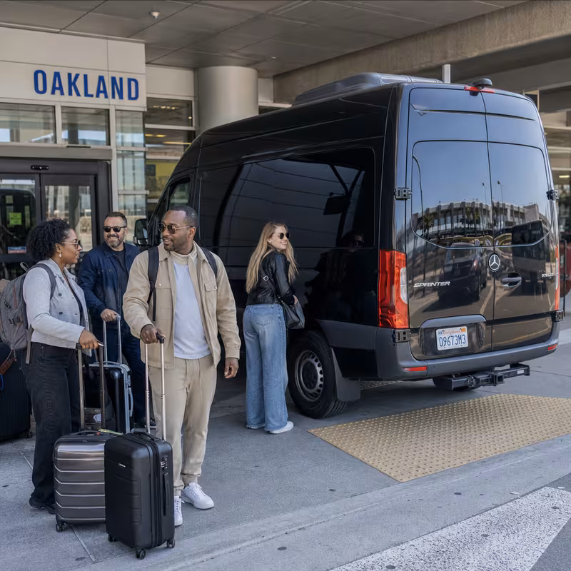 Group boarding a white charter bus for Airport Transportation transportation in Oakland