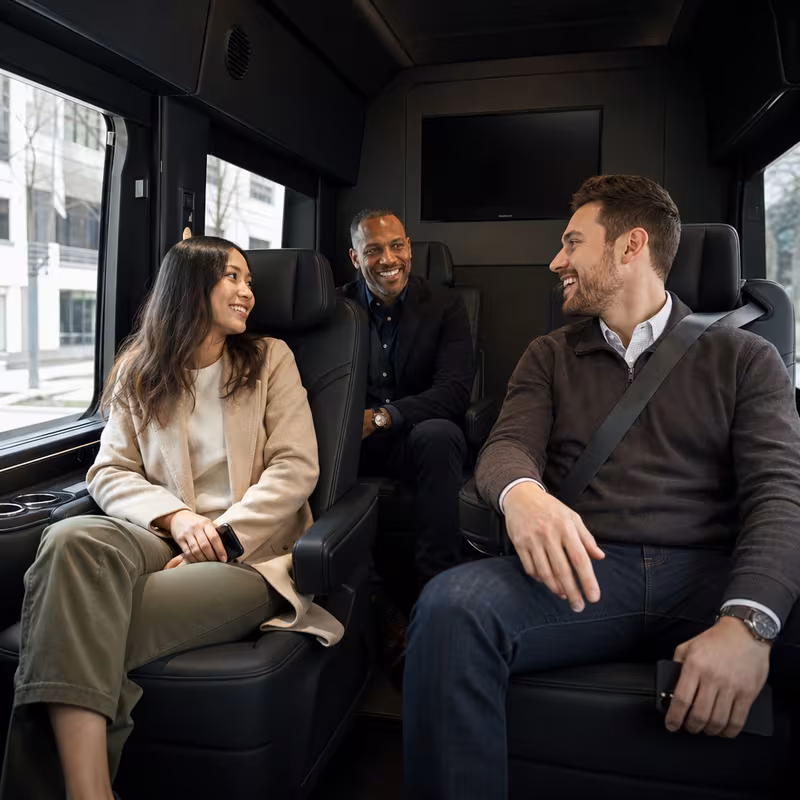 Group boarding a white charter bus for Corporate Transportation transportation in Oakland