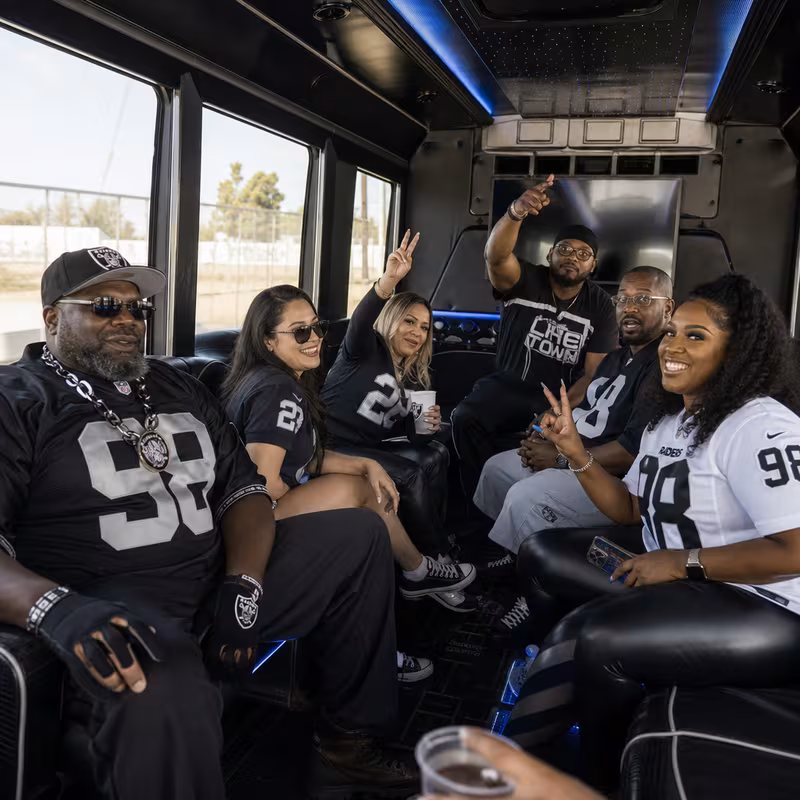 Group boarding a white charter bus for Sporting Event Transportation transportation in Oakland